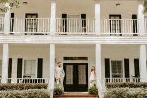 Bride and Groom on the front porch of the manor house at All4One Farms.
