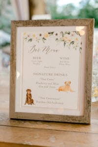 Bar sign with drinks selections that have been named after a bride and groom's dogs.