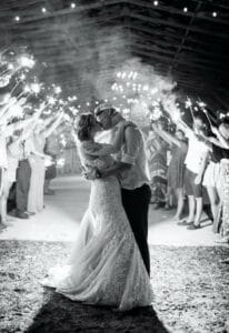 Bride and Groom kiss as they exit their reception to a host of sparklers.